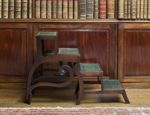 Regency mahogany library steps which fold up to form a sabre-leg armchair - the "Patent Metamorphic Library Chair" by Morgan and Sanders, in the Library at Saltram, Devon.
