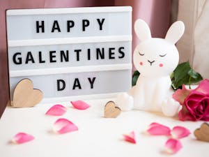 Charming Galentine's Day setup with a bunny figurine, roses, and heart decor.